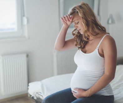 Pregnant woman suffering with headache and nausea