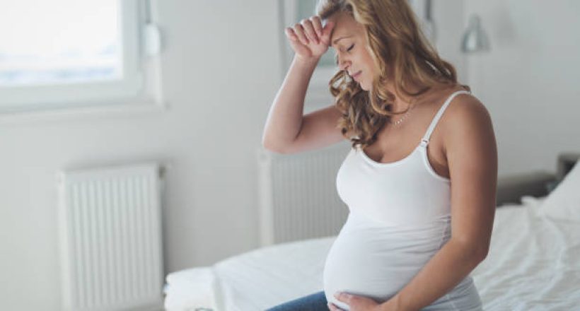 Pregnant woman suffering with headache and nausea Pregnant woman suffering with headache and nausea