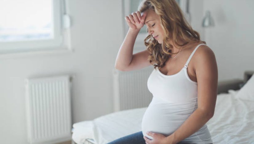 Pregnant woman suffering with headache and nausea